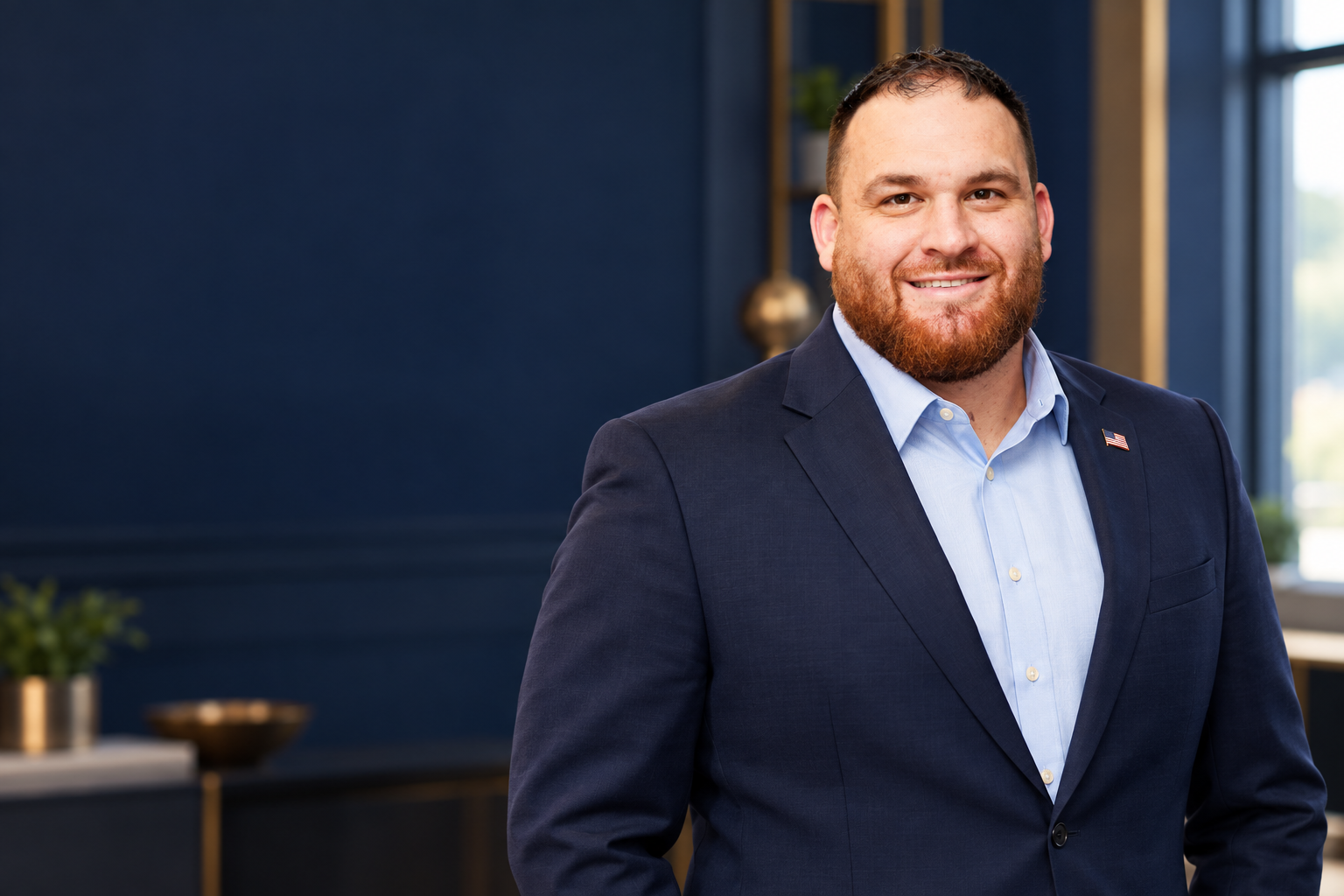 Concept portrait of Rob Hamilton in a navy suit with an American flag lapel pin